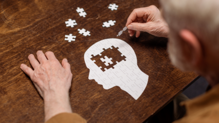 Elderly man doing jigsaw of human head