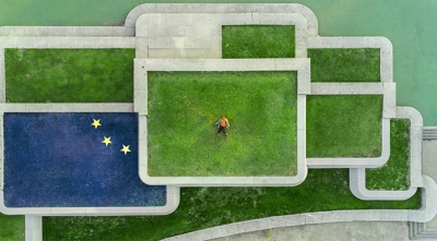 Man laying on intersecting lawns with EU flag