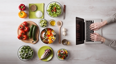 Laptop and multiple plates of food