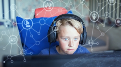 Child using computer with background visualisation of social networks