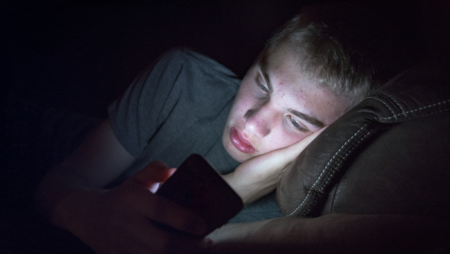 Unhappy teen looking at phone
