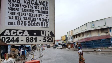 Poster on the side of a house outlines job vacancies.