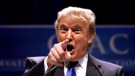 Donald trumps points to the camera mid-word.