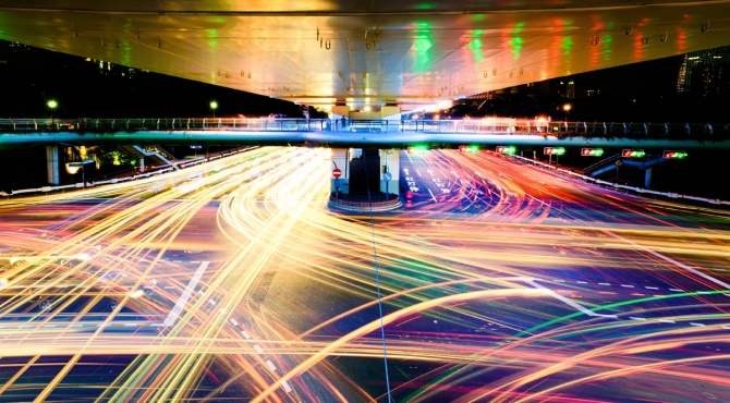 Long exposure image of a highway interchange, showing hundreds of trails left by headlights and brake lights.