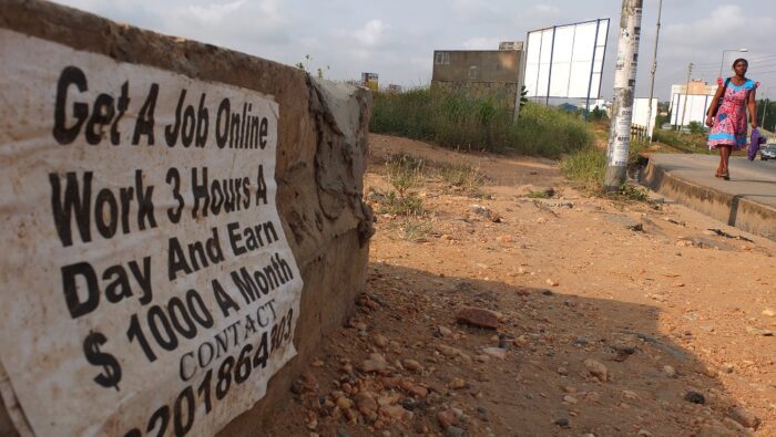 Advert on a wall reading 'Get A Job Online. Work 3 Hours A Day And Earn $1000 A Month.'