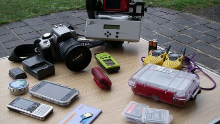 Digital ethnography equipment, including a camera, dictaphone, radios, and telephones.