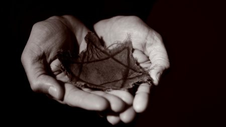 Close up image of man's hands holding ragged Jewish badge