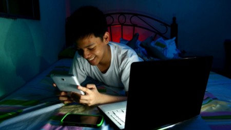 Child using internet devices in bedroom