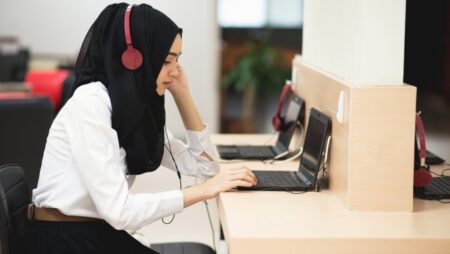 Person in a hijab uses a laptop.