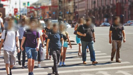 Urban surveillance concept. Pedestrians at street crossing with pixellated faces to represent facial recognition technology